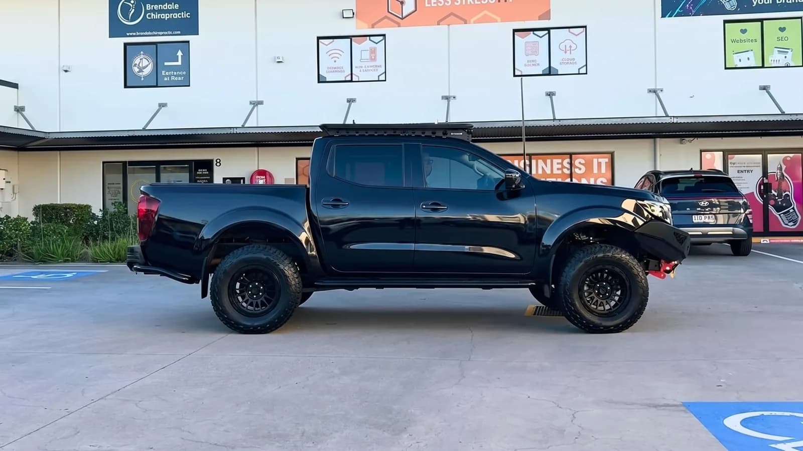 Plain gloss-black dual-cab ute before signage
